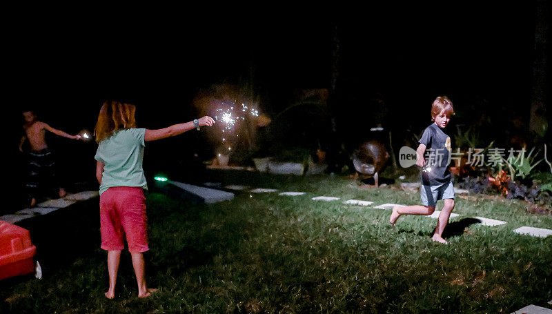 Child holds a sparkler firework at night in the dark